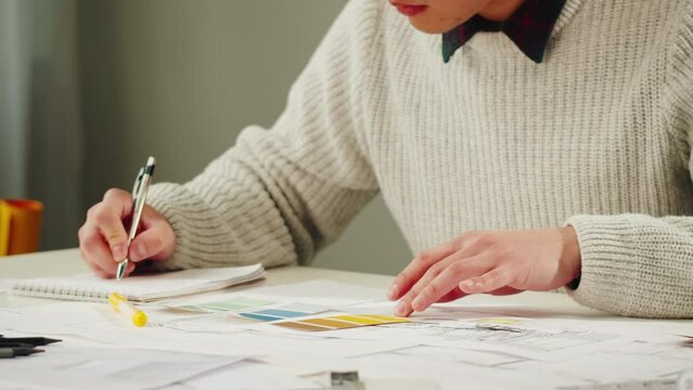 Architect designer workplace close-up. Professional engineer choosing color palette, interior creator working with house project, blueprint plan, drafting building.