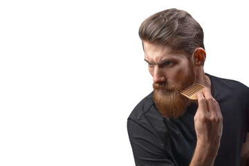 Bearded man with hair brush. Trendy and stylish beard styling and cut. Brutal young bearded man....