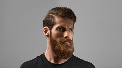 Fashion model with stylish hair and beard. Man with long beard and mustache on serious face isolated on grey background. Barber fashion and beauty.