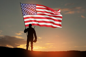 Silhouettes of soldier with USA flag against the backdrop of a sunset. Greeting card for Veterans...