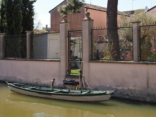 Comacchio, Italy. Historic center, house along the bank of the canal with landing place. There is a small boat.