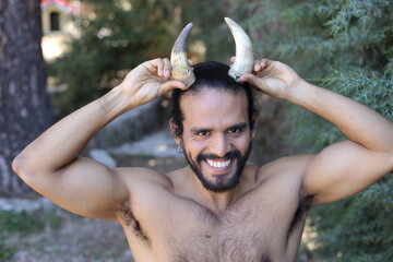 Shirtless muscular man with pair of horns