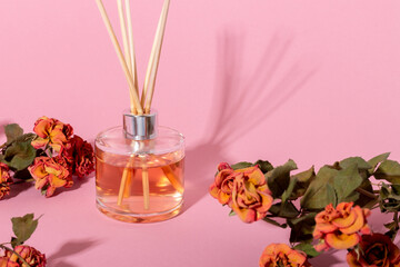 reed diffuser with flowers. Incense sticks for the home with a floral scent with hard shadows. The concept of eco-friendly fragrance for the home