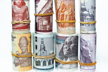Egypt money roll pounds banknotes isolated on white background, Egyptian pounds cash money bills rolled up with rubber bands of 200 LE, 100, 50, 20, 10, 5, 1 pound and 50 piasters, selective focus - obrazy, fototapety, plakaty
