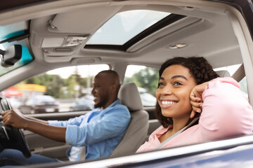 Happy black couple enjoying drive on new car