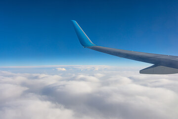 Wing view of the airplane on a winglets, stratus clouds on the skyline during climbing flight level.