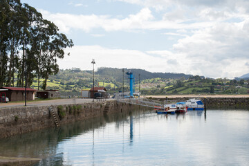 Asturian coast. Small harbour at El Puntal with two boats. Calm water, cloudy sky