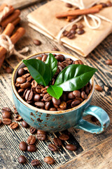 Cup full of coffee beans on wooden table