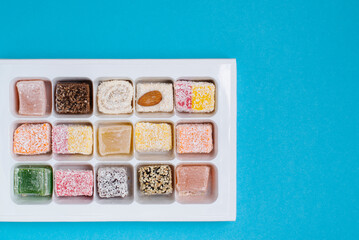 sweets in a square box with nuts on a blue background