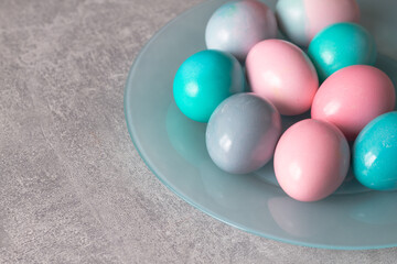 Light pink and turquoise, blue eggs on a blue plate and a gray background for the Easter holiday