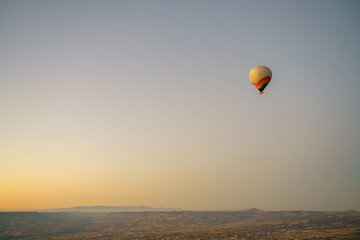 Colorful balloon flying over Cappadocia with a clear cloudless sky, copy space