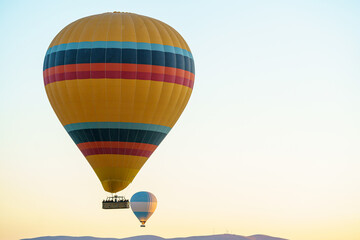 Colorful balloon flying over a clear sky during a sunset on a sunny day in Cappadocia, Turkey