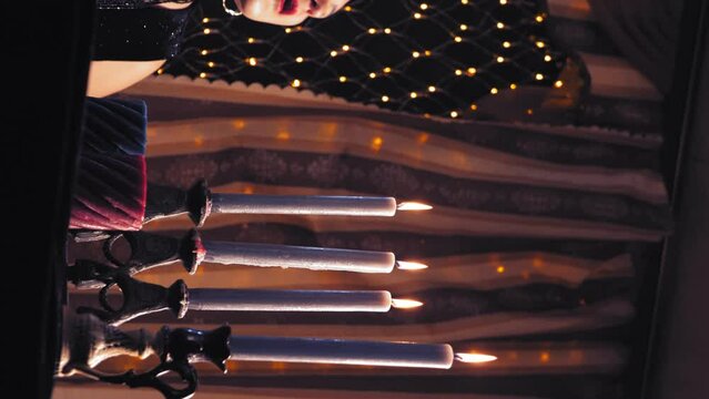 woman bald witch blows out candles after work. vertical video