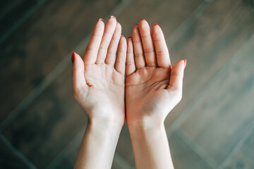Young caucasian woman showing palms, top view.	