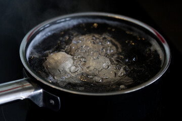 Saucepan with boiling eggs in kitchen