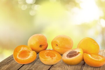 Orange fresh ripe apricots with leaves on a wooden table