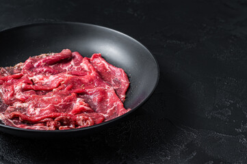 Marbled beef meat carpaccio. Black background. Top view. Copy space