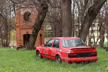 Stare auto porzucone w parku. Old car abandoned in the park. 