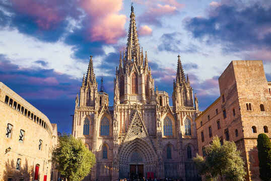 Gothic cathedral in Barcelona, Catalonia, Spain. Entrance in Barcelona Cathedral with tower. Ancient architecture of old town with medieval houses. Blue evening sky with clouds and antique street.