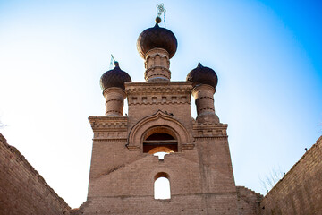 Obraz premium Old ruined church. Bent crosses and broken walls of the temple, ancient forged frames on the windows. Christian monastery.
