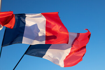 drapeaux français dans le vent avec un beau ciel bleu en arrière plan. Symbole de la démocratie,...