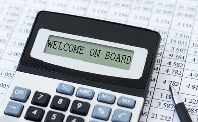 Welcome on board text on the display of the calculator on the background of reports on the table, business concept