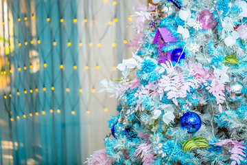 Christmas decorations in the interior. Festive background. New Year's room design, beautiful and shiny toys on the Christmas tree. Blurred background with copy space for text.