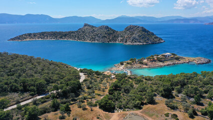 Obraz premium Aerial drone photo of iconic Aponisos bay and lake with clear turquoise sea and pine trees, Agistri island, Saronic gulf, Greece