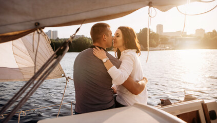 Romantic vacation . Beautiful couple kissing in sunset from the yacht.
