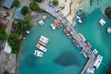  Aerial view of expensive yachts and jetty from above in private cove on Praslin, Seychelles.