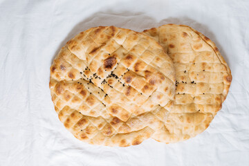 Top view of traditional Turkey or Bosnian pita bread called Somun or Lepina. Popular bread to eat during the month of Ramadan or Eid Mubarak. Rustic wooden backround