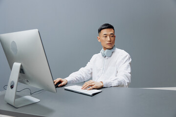 Asian man in headphones at the table in front of the computer Lifestyle work