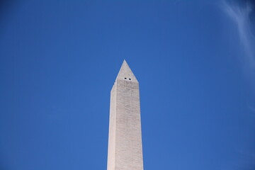 The white Washington Obelisk monument in the blue sky