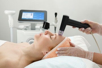 A woman receives laser treatment of the face in a cosmetology clinic, a concept of skin rejuvenation is being developed. laser peeling