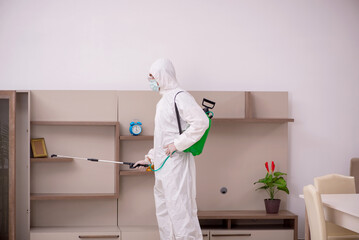 Fototapeta premium Young male contractor doing pest control at home