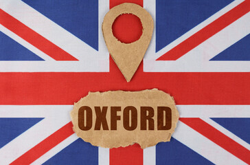 On the flag of Great Britain lies a symbol of geolocation and cardboard with the inscription -...