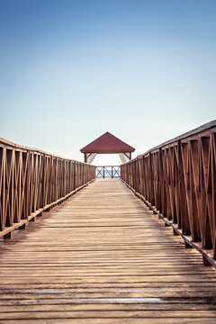 Beach planked pier leading into the sea with clear blue sky and turquoise water as vacation lifestyle scenery