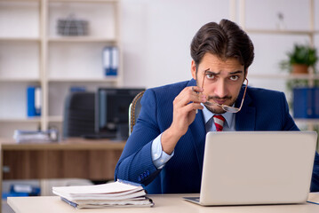 Naklejka premium Young male employee working in the office