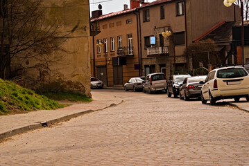Uliczka ze starą przedwojenną zabudową , w pobliżu rynku w Ostrowcu , z parkującymi samochodami.