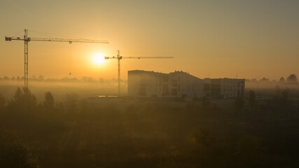 City construction site including cranes, with lots of gold sunlight