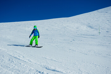 Action snowboarder boy go downhill image on snowboard, side view
