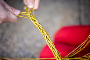Man, teaching his child how to weave his easter whip from a rod