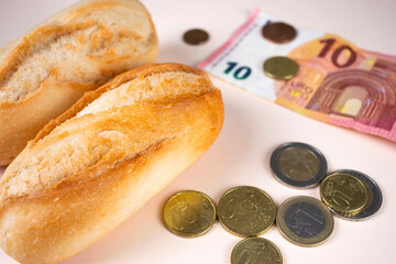 Price of bread, white bread loaf with euro money and coins. Expensive food because of inflation,...