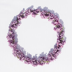 Natural round frame made od purple lilac flower on a white background. Flat lay. Minimal concept for Mother's day, weddings, spring and other pruposes. 