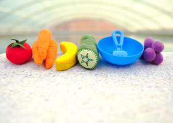 fruits of toys with the colors of the LGTBIQ+ collective flag on the edge of a swimming pool.
