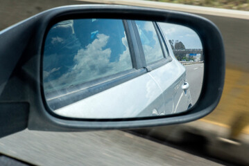 Obraz premium Retrovisor copiloto con reflejo de nubes