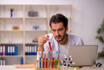 Young male chemist working at the lab