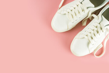 Pair of white sneakers on pink background. Unisex shoes, stylish white sneakers. Top view, flat lay, mockup with copy space for text