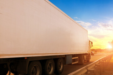 Close-up of the big truck with a trailer on a countryside road against a sky with a sunset - 501013259
