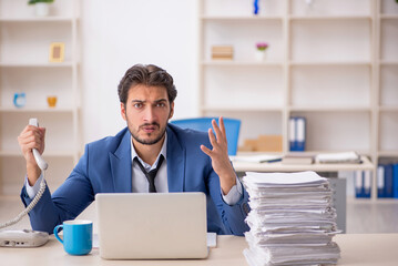 Young male employee and too much work in the office